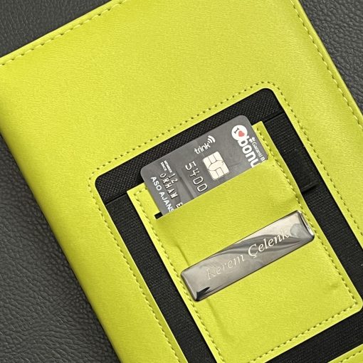 Kart cebi ve lazerle isim yazılmış metal plaka yakın çekim, kişiye özel defter