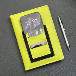Telefon ve kart cebi dolu A5 kişiye özel defter, yanında metal tükenmez kalem