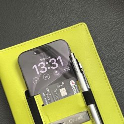 Cepteki telefon, kart ve kalemle logolu kişiye özel defter yakın çekim